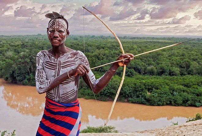 A young Ethiopian Karo boy holding a bow and arrow