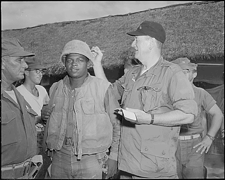 John Wayne signs the helmet of Pfc. Fonzell Wofford during a visit at Chu Lai, South Vietnam in June 1966