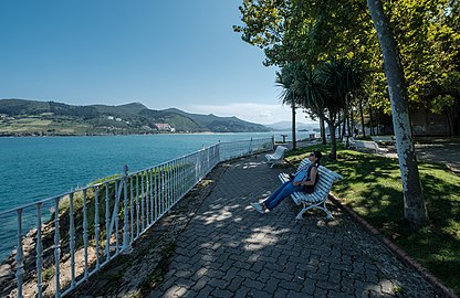 Woman sits by the shadow, Mundaka, Spain