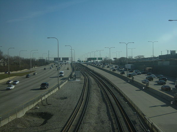 Southeastward view of the Kennedy Expressway from the Montrose Blue Line Station, with the reversible express lanes to the right of the tracks