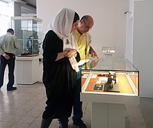 Visitors examining fossils displayed at the National Museum of Iran in Tehran, Iran Lower Paleolithic fossils from Darband Cave, Paleolithic hall, National Museum of Iran.jpg