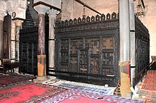 Photographie de la façade de la maqsura, clôture en bois de cèdre sculpté et ajouré, qui se trouve au fond de la salle de prière, à côté du minbar.
