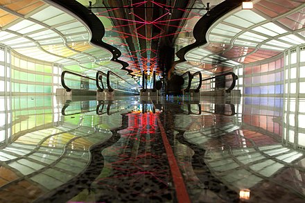 A neon-filled walkway connecting Concourses B and C in Terminal 1
