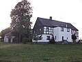 Residential stable house, northern side building, western barn and paving of a four-sided courtyard