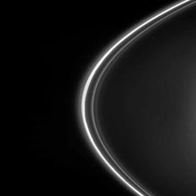The small moons Pandora (left) and Prometheus (right) orbit on either side of the F ring. Prometheus acts as a ring shepherd and is followed by dark channels that it has carved into the inner strands of the ring.