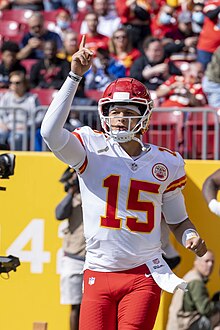 Patrick Mahomes with his arm raised, pointing up
