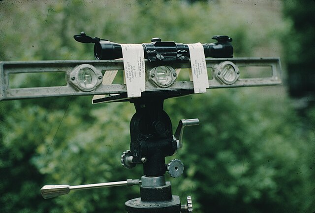 An improvised surveyors level made from a camera tripod, a torpedo level and a sniper scope.