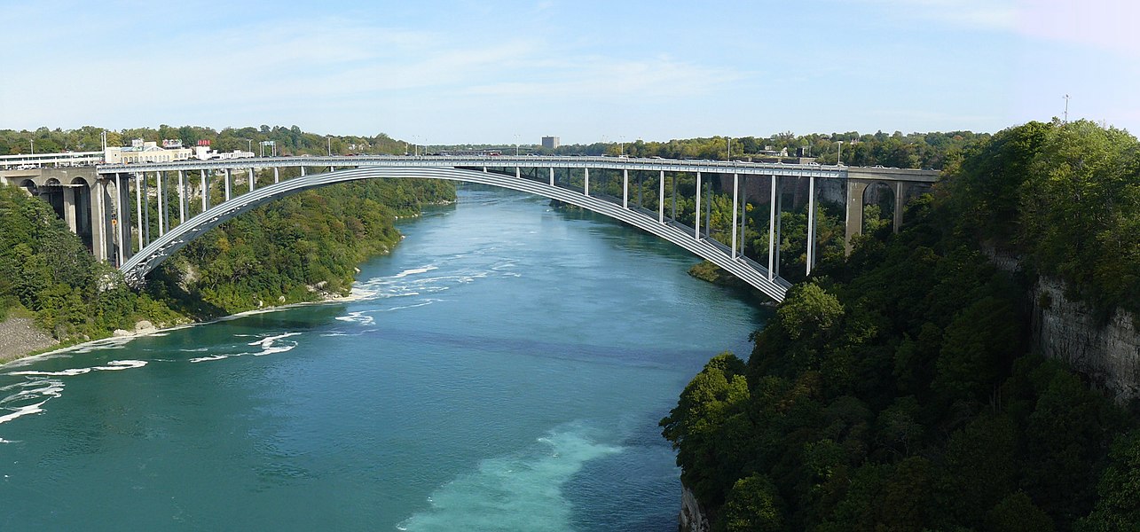 The Rainbow Bridge across the Niagara River, connecting Canada (left) to the United States (right). The parabolic arch is in compression and carries the weight of the road.