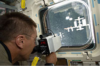 Кристофер Кэссиди, с помощью специального прибора, измеряет расстояние до МКС.