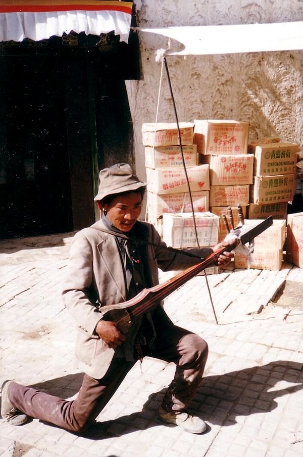 Street musician playing a dramyin, Shigatse, Tibet, 1993