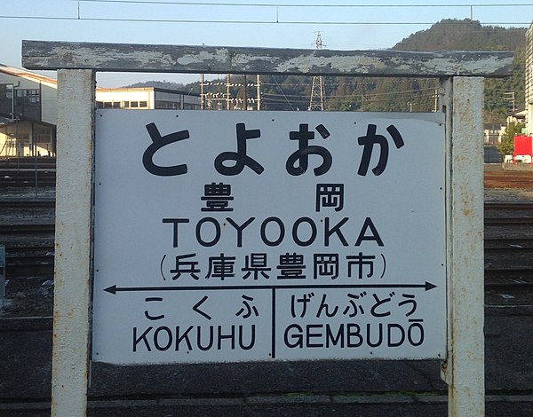 Former Japan National Railways-style board of Toyooka Station. For the two adjacent stations, "GEMBUDŌ" follows the Hepburn romanization system, but "