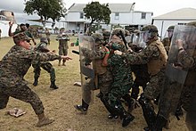 American marines and Caribbean soldiers clashing during a riot control training exercise in 2011 USMC-110306-M-5797H-224.jpg