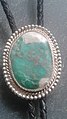 Variscite and silver bolo tie. This variscite specimen contains inclusions of white crandallite and is from Clay Canyon near Fairfield, Utah