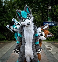 Three people dressed in fursuits, representative of their respective fursonas.