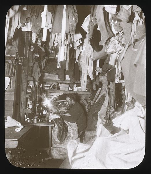 File:A corner of the hut, Bage mending his sleeping-bag (Australasian Antarctic Expedition, 1911-1914, 1) (6173954058).jpg