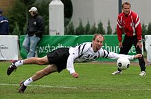 A fistballer defends the ball at full stretch A fistballer defends the ball at full stretch.jpg