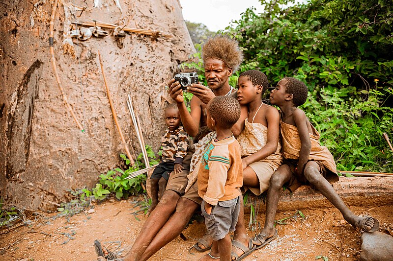 File:A man and children explore a camera in Tanzania.jpg