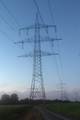 An electricity pylon west of Eggenstein-Leopoldshafen, Germany, standing over a gravelled way.