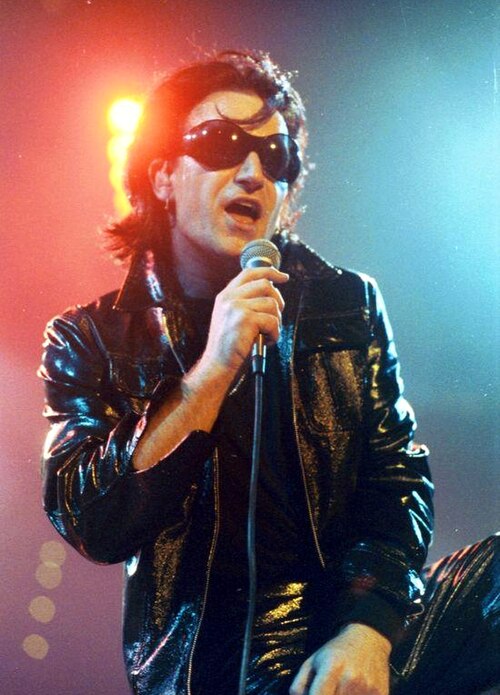 Bono in 1992 as his persona "The Fly", a leather-clad egomaniac meant to parody rock stardom. He conceived this character during the band's 1991 recor