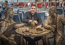 Msgr. James Shea, seated at the statue of the Monk and Marauder in the Crow's Nest Crow's Nest Monk and Marauder.jpg