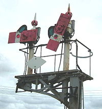 A semaphore signal fitted with a diamond sign indicating there is no need to contact the signaller Diamond sign.jpg