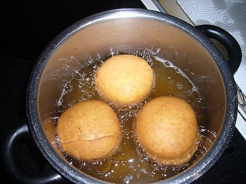 Three carnival doughnuts being fried