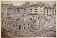 Photographie ancienne en noir et blanc montrant le palais de la Bourse en construction.