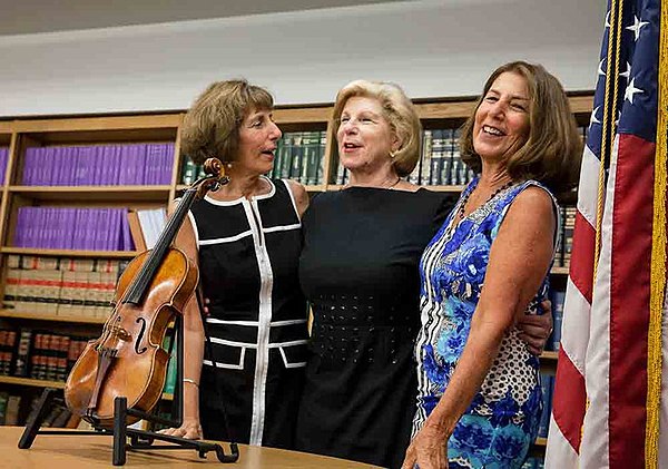 From left, Jill, Nina, and Amy Totenberg celebrate the return of their father’s Stradivarius violin in 2015.