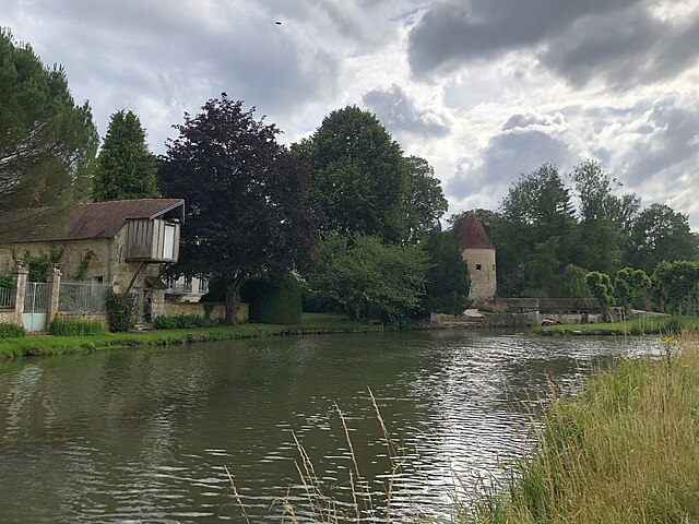 Rivière de l'Ourcq canalisée. A gauche, un ancien grenier à grain. Puis la passerelle Eiffel, une tour des fortifications et le Mail.