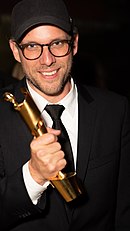Ansgar Frerich, producer of the German Award for Best Documentary Film 2019, Of Fathers and Sons, holding the Lola statuette