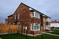 A photograph of a single semi-detached house of the 'Malet Close' development on the corner of James Reckitt Avenue and Clifford Street in Kingston upon Hull.