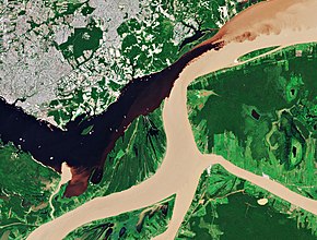 Sentinel-2 satellite image of the confluence of the Rio Negro and the Solimoes River, Brazil. The Rio Negro in the upper left part of the image is dark due to high concentrations of colored dissolved organic matter (CDOM). The Solimoes River in the lower and right part of the image is brighter because of large amounts of sediments. Negro-Amazon confluence and Manaus (Brazil) from space (cropped).jpg