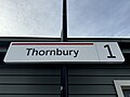 One of the new style white background and red line signage at Platform 1, July 2024