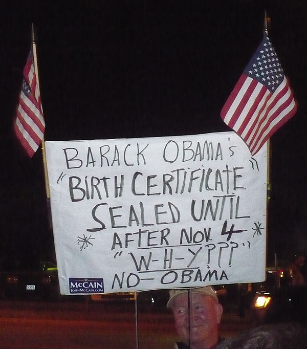 A protester questioning the legitimacy of Obama's birth certificate