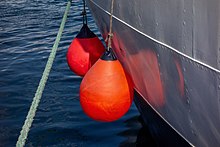 Two orange fenders protecting the side of a moored sailing vessel Orange fenders on schooner Alva in Lysekil.jpg