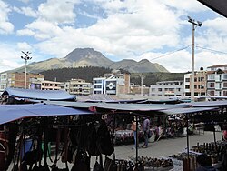 Kunsthandwerkermarkt auf der Plaza de los Ponchos in Otavalo mit dem Imbabura im Hintergrund