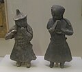 Pottery figurines of musicians (a flute player on the left, and a someone beating clappers on the right)