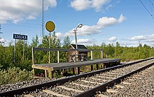 The Sjisjka stop on the Inland Line in Lapland with the traditional round, yellow sign that is to be turned towards the arriving train Sjisjka station 1708 2008b.jpg