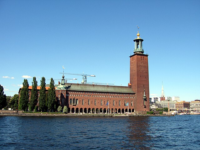 Stockholms stadshus invigdes den här dagen för 101 år sedan. Byggnadens karaktäristiska torn är en välkänd silhuett i staden och har blivit något av en symbol för Stockholm.