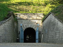 Entrée d'un tunnel dans une colline.