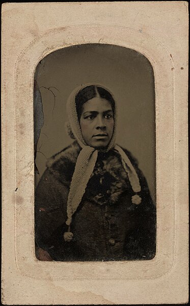 File:Bust portrait of lady wearing coat with fur collar, light crocheted head scarf with tasseled terminations. Tintype, sixth plate.jpg