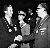 Fekete-fehér fénykép két fiatal férfi kezet fogott.