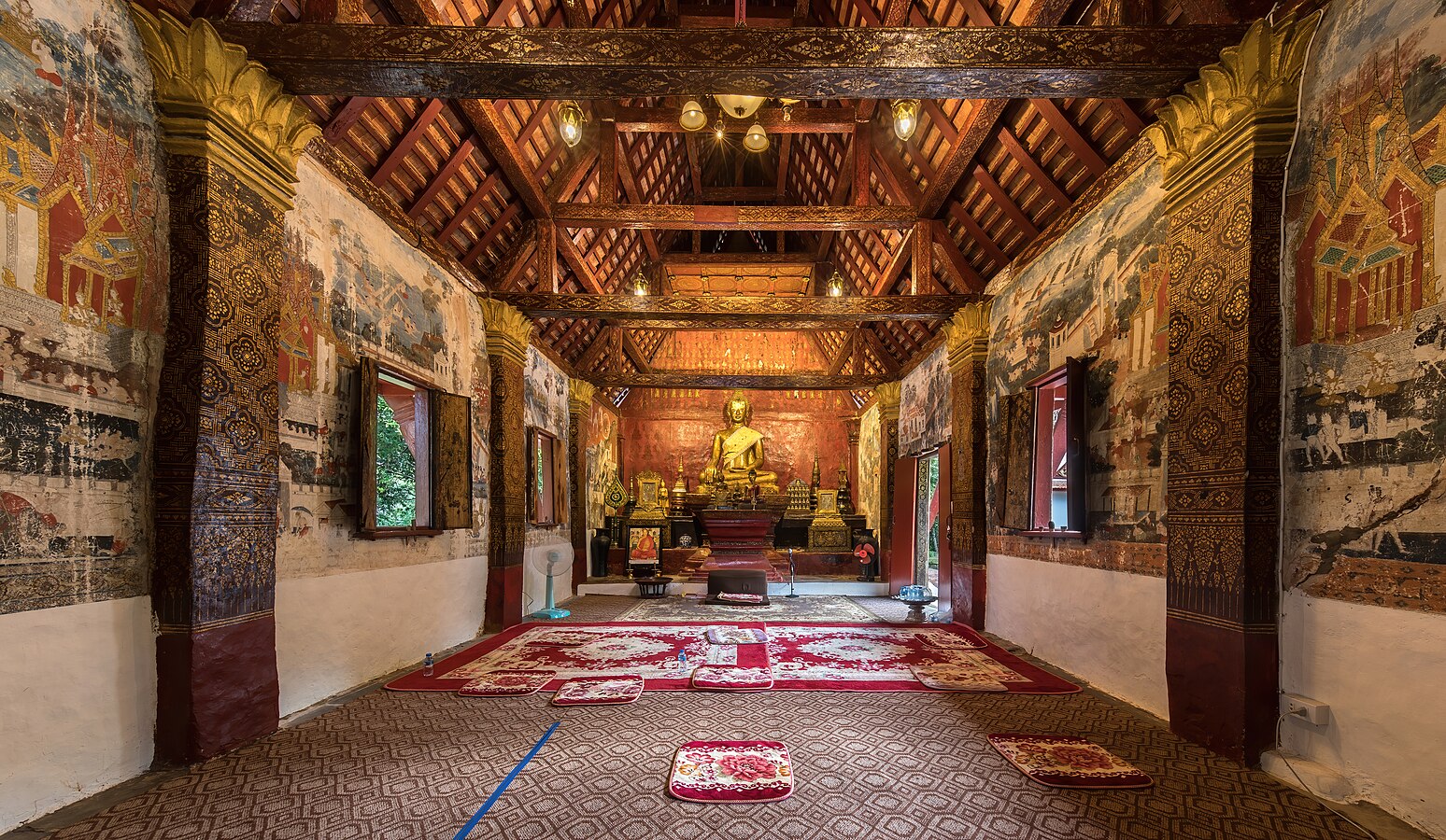 Interior of Wat Long Koon with gold statue of the seated Buddha in Luang Prabang Laos