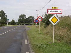 Panneau d'entrée d'agglomération suivi d'une limitation de vitesse à 70 km/h