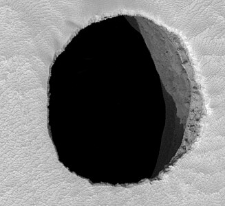 HiRISE image du trou de "Jeanne" sur Mars, d'environ 150 mètres de diamètre et d'au moins 178 mètres de profondeur.
