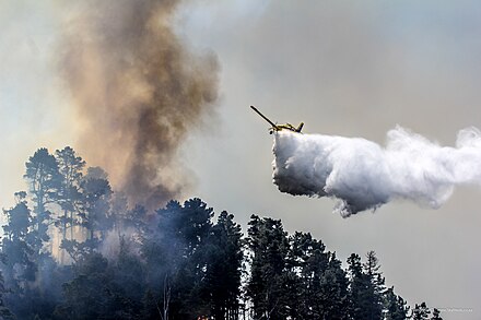 A firefighting aircraft dumping water on a forest fire in South Africa.