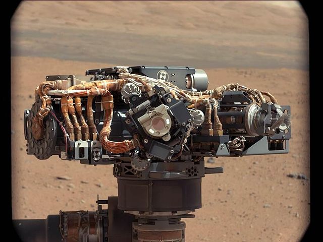 Curiosity's (MSL) rover "hand" featuring a suite of instruments on a rotating "wrist". Mount Sharp is in the background (September 8, 2012).