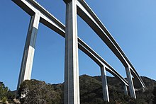 新東名では最も高い橋梁の新佐奈川橋。近距離からの圧迫感を低減するための意匠的配慮を行なった。高橋脚の縦方向にスリットを入れ、断面を八角形とすることで、陰影効果とも相まって優美さを引き出し、圧迫感を感じさせないように配慮された[408]。