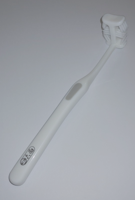 A six-sided toothbrush used to brush all sides of the teeth, in both the upper and lower jaw, at the same time.