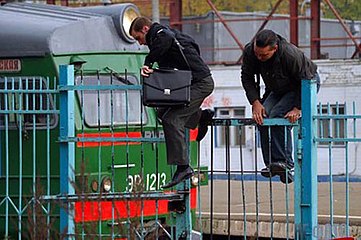 Climbing over fence of a commuter train station in Moscow, Russia.